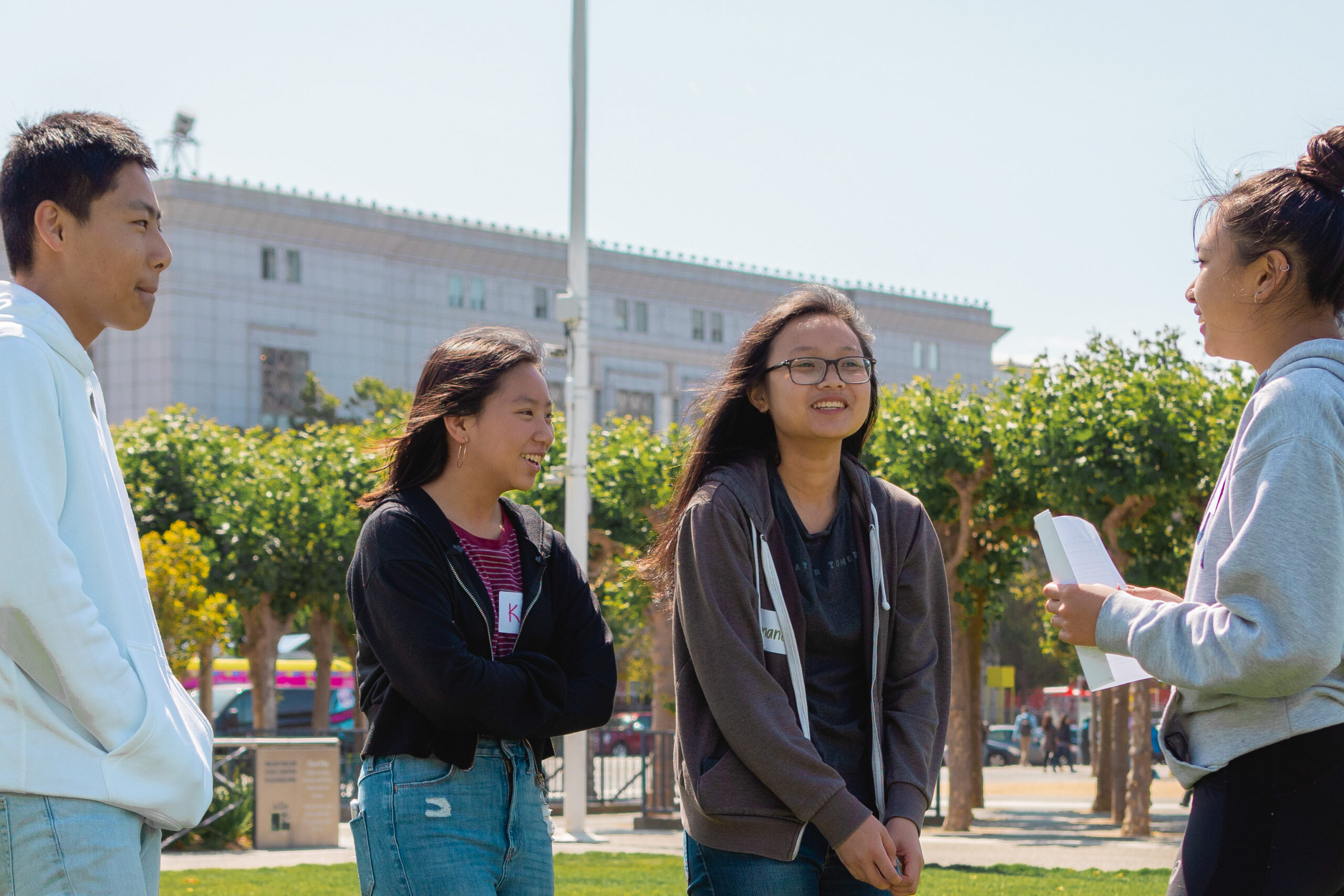Four AAMPLIFY students discuss how to proceed with a project at Civic Center Plaza, San Francisco.
